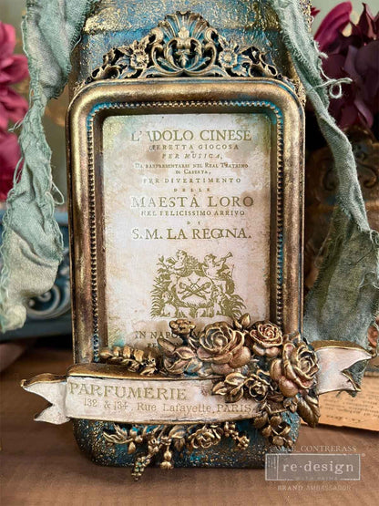 Decorative vintage-style frame with intricate details and text, featuring a floral design.